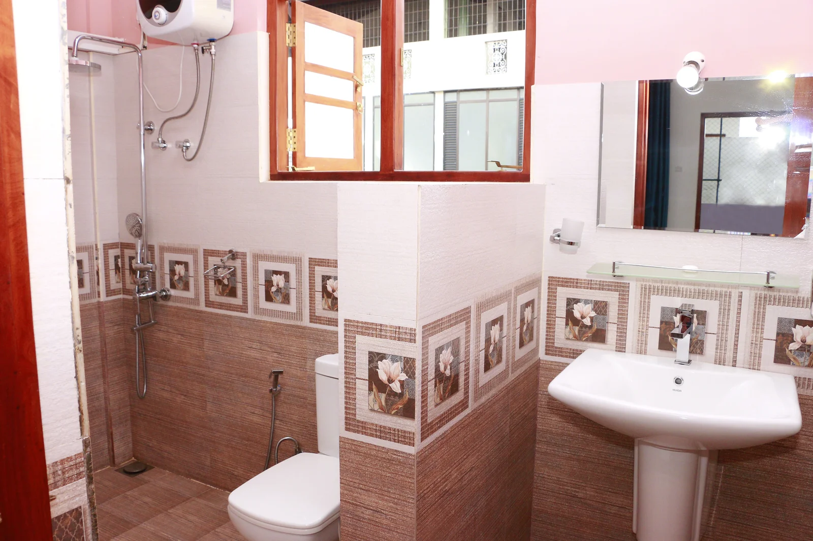 Deluxe Double Room 2 — Modern en-suite bathroom with vanity mirror, hot shower and amenities