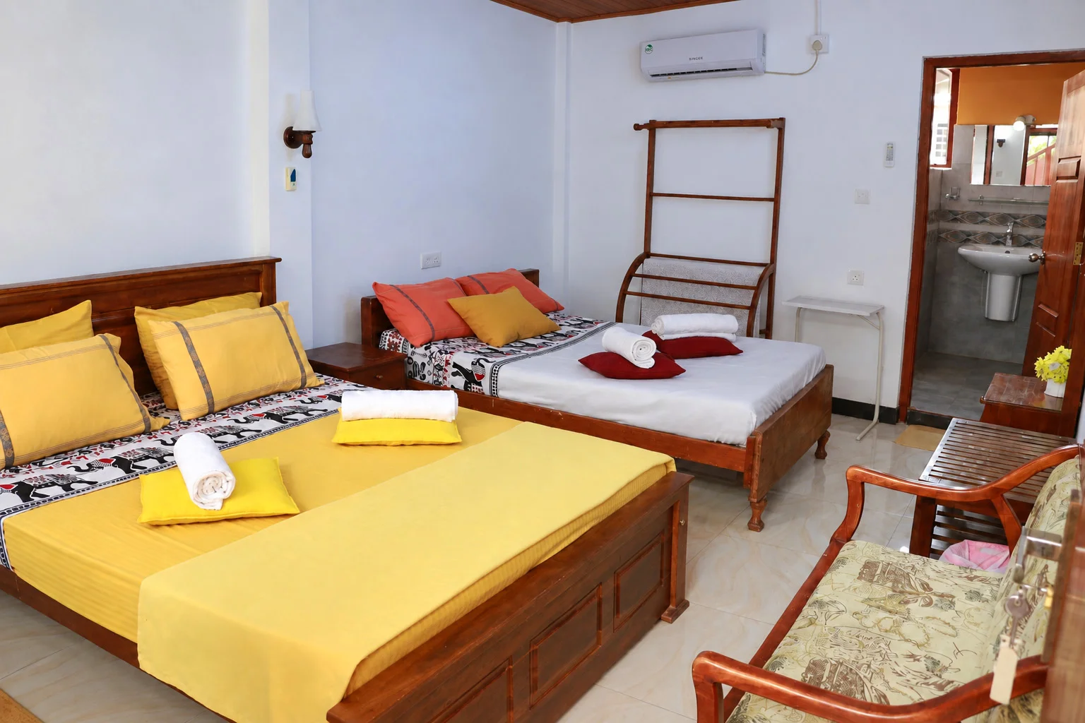 Deluxe Family Room — Air-conditioned guestroom with elegant headboard, wall decor and ceiling fan
