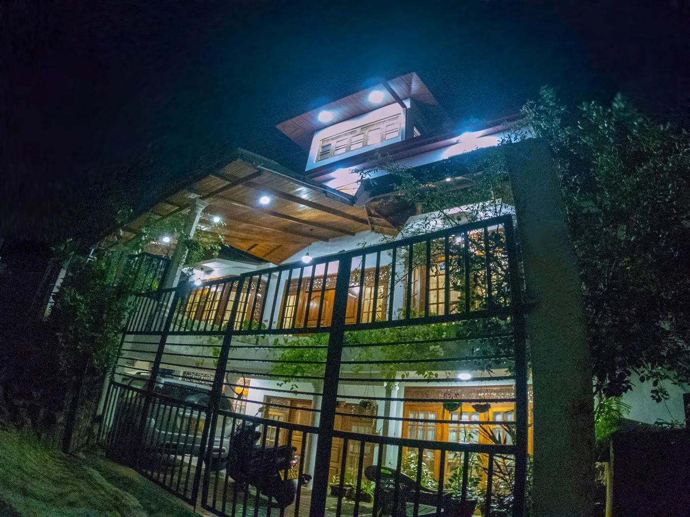 Innovick Residence lit up at night, seen from the road outside the front gate