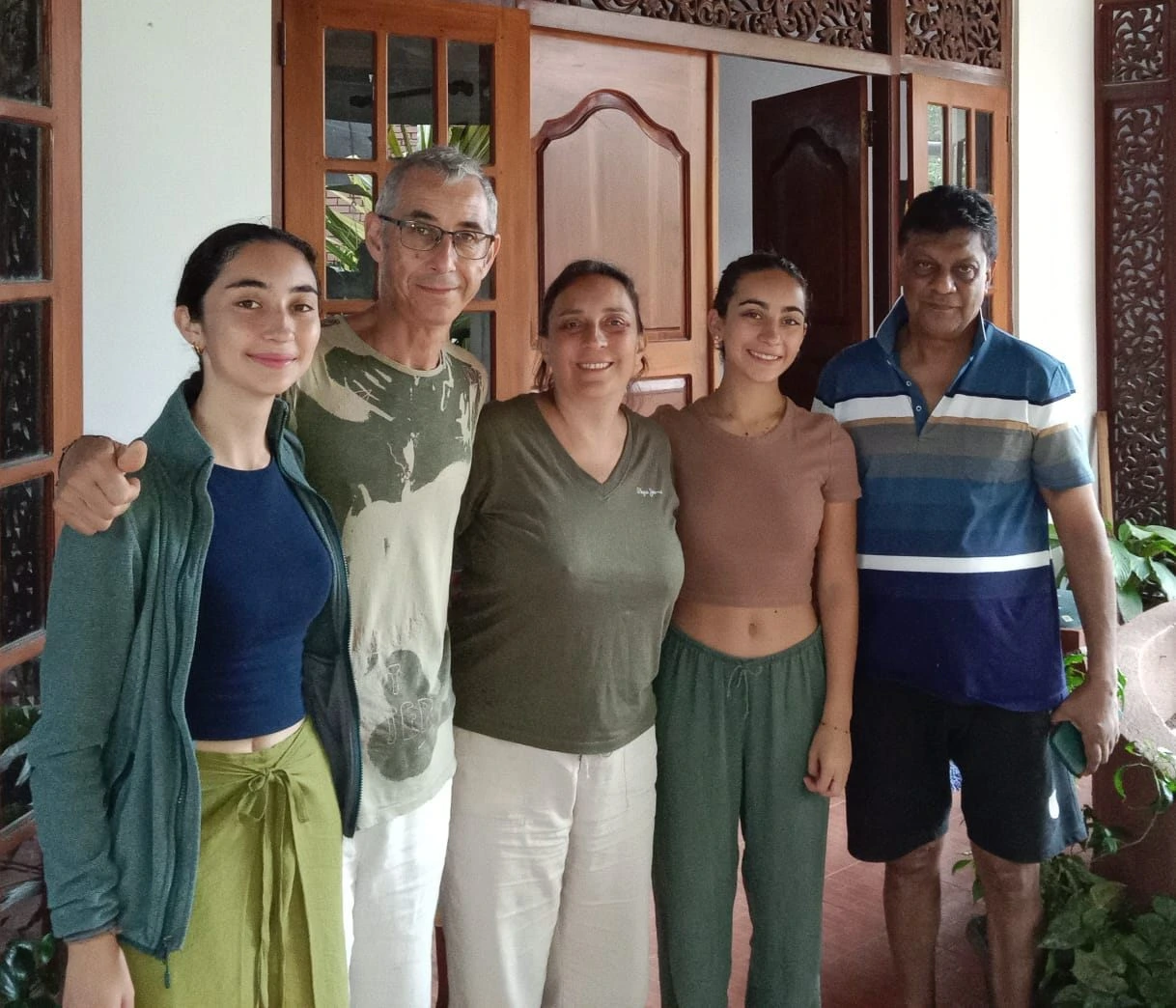 A group of four guests photographed with their host on the front veranda
