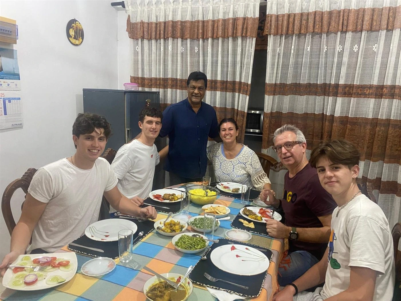 Guests and their host around a home-cooked Sri Lankan dinner of rice and curries