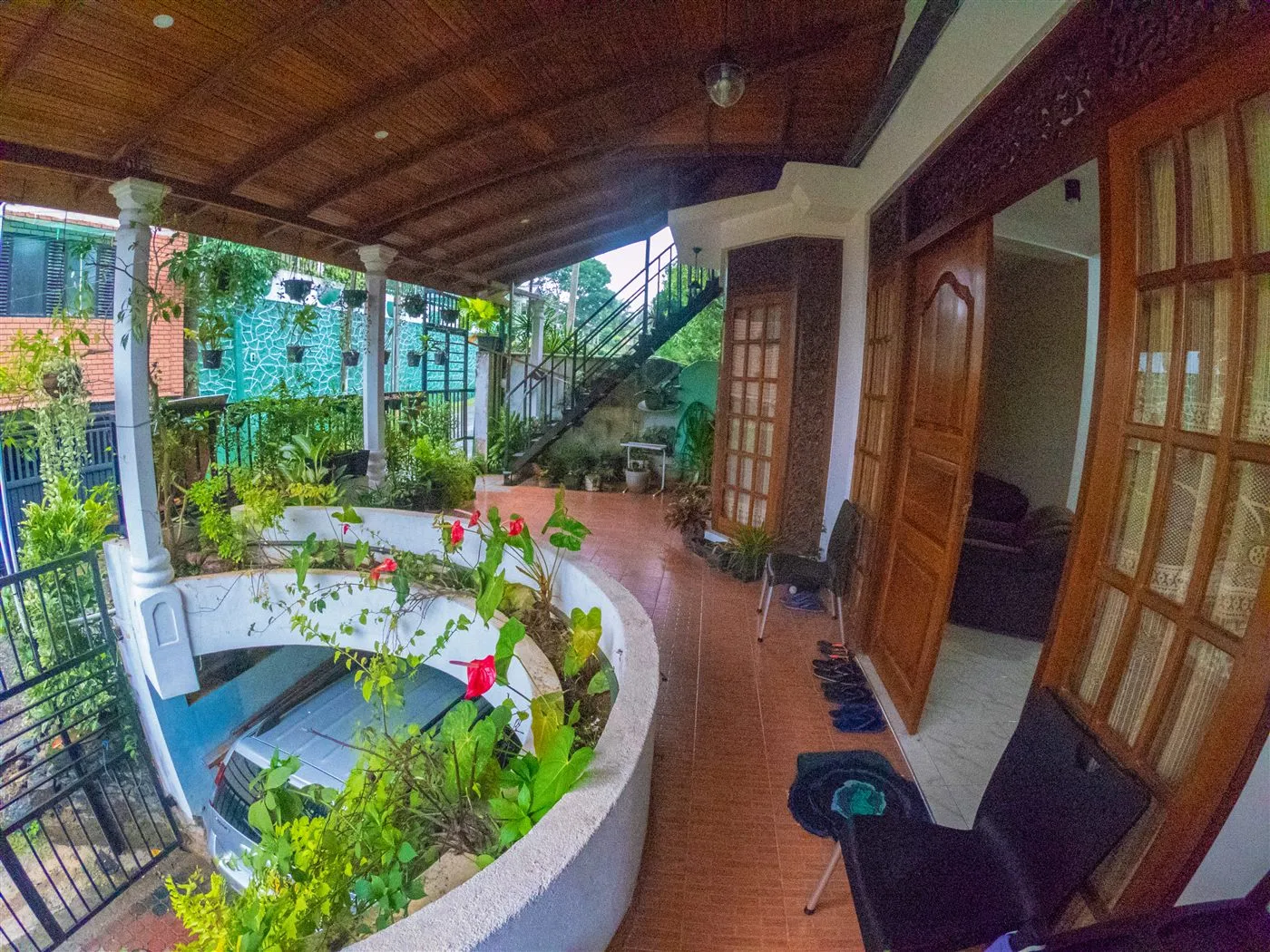 Innovick Residence garden veranda with wood carved doors and relaxing seats