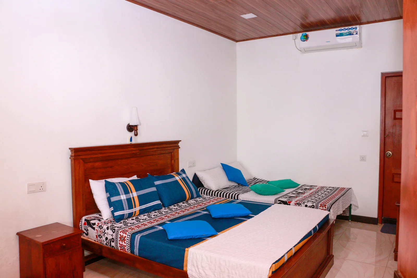 Deluxe Triple Room — Detailed view of the comfortable bed setups and wooden craftsmanship